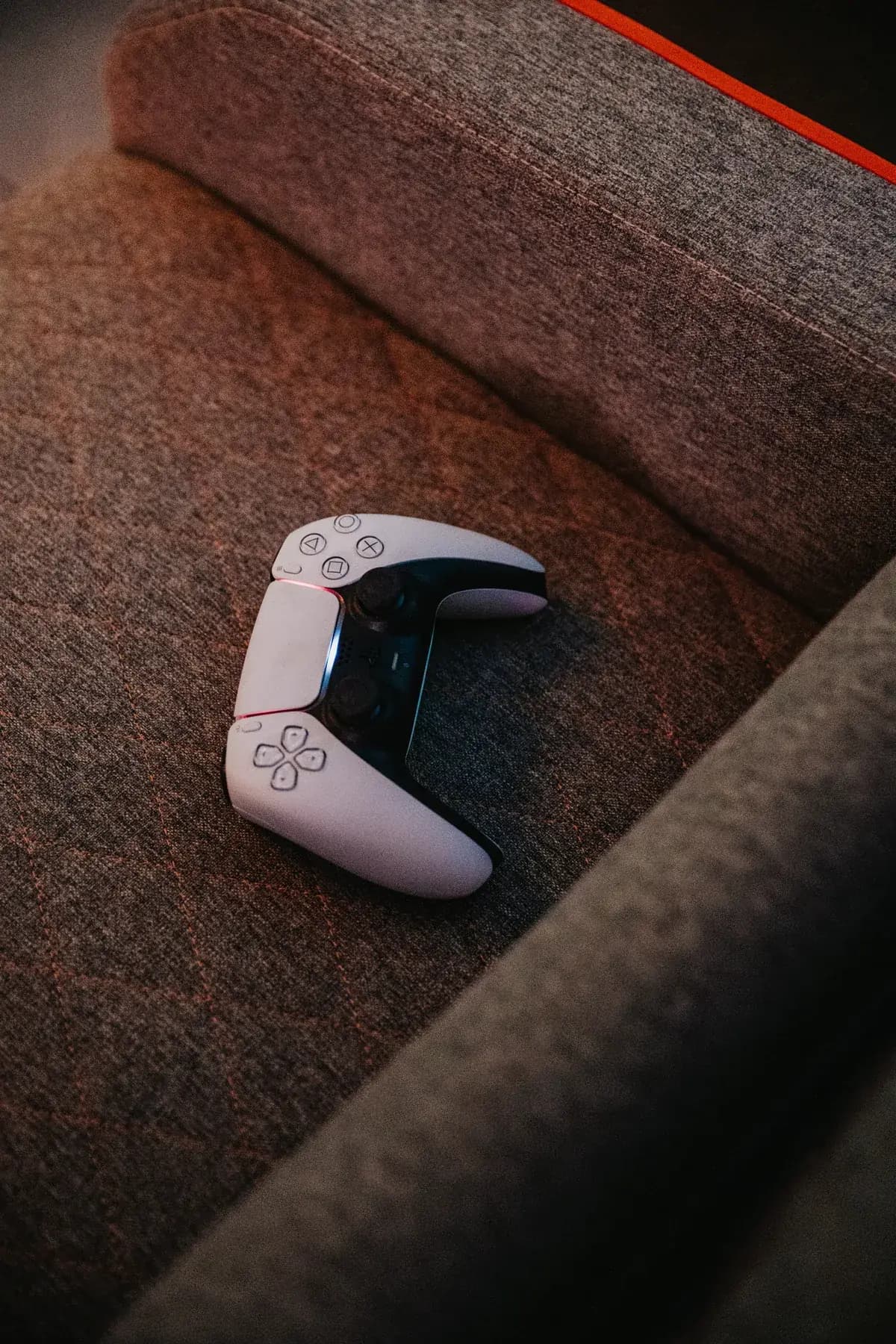 Joystick de PlayStation 5 apoyado en un sillón