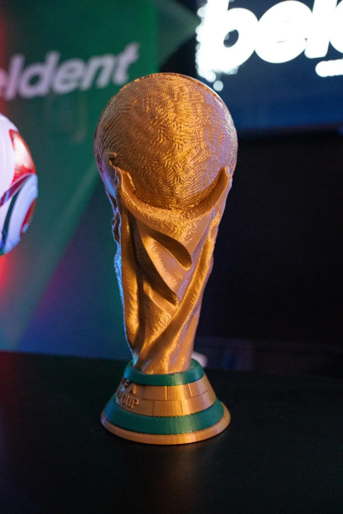 La copa del torneo iluminada por los neones del local